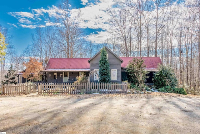 ranch-style home featuring a fenced front yard and metal roof