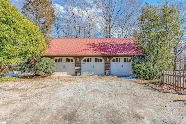 detached garage featuring fence