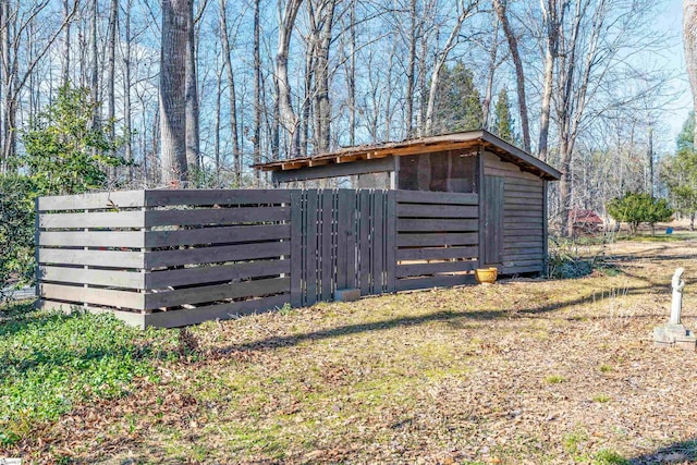 view of outbuilding with fence and an outbuilding