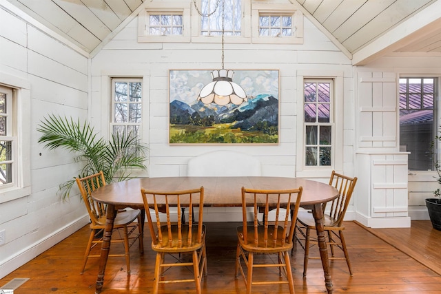 dining room with vaulted ceiling, hardwood / wood-style floors, and visible vents