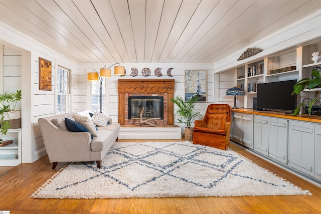 interior space with built in shelves, hardwood / wood-style floors, a brick fireplace, and wood ceiling