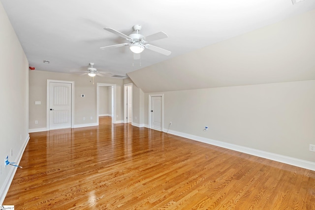 bonus room with light wood-type flooring, baseboards, a ceiling fan, and lofted ceiling