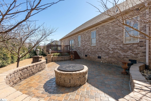 view of patio featuring an outdoor fire pit and a deck