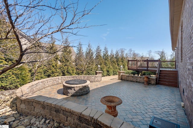 view of patio featuring an outdoor fire pit and a wooden deck