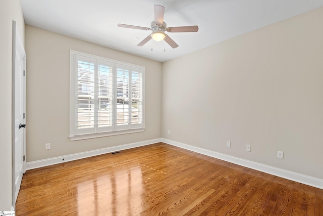 spare room featuring visible vents, baseboards, and wood finished floors