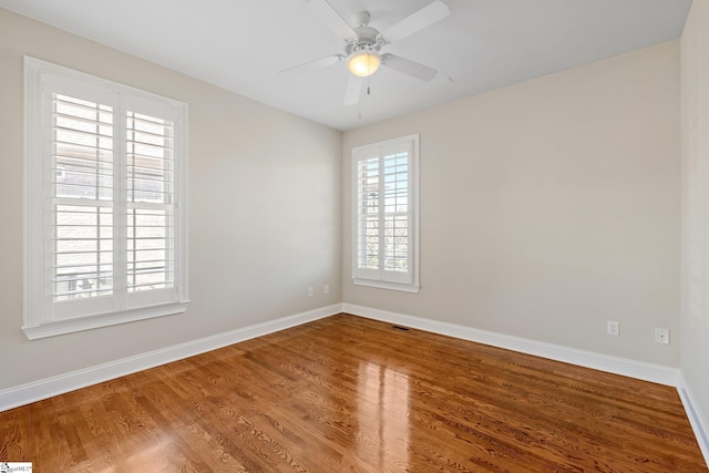 empty room featuring plenty of natural light, baseboards, and wood finished floors