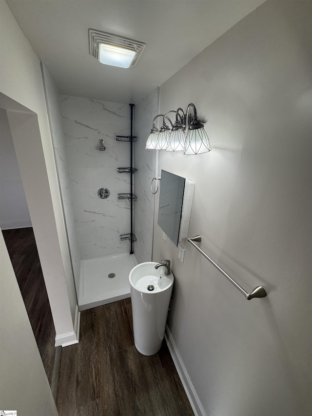 bathroom with baseboards, wood finished floors, visible vents, and a shower stall
