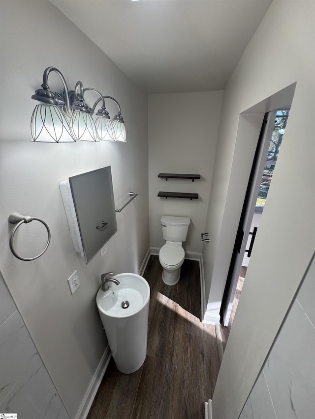 bathroom featuring toilet, baseboards, and wood finished floors