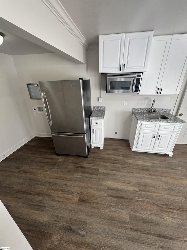kitchen featuring crown molding, dark wood finished floors, stainless steel appliances, and a sink