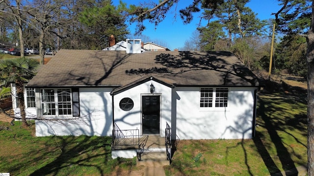 view of front of property with a front lawn and a chimney
