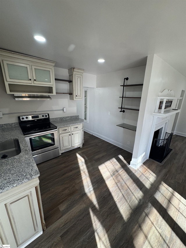 kitchen featuring electric range, dark wood-type flooring, a fireplace, a sink, and baseboards
