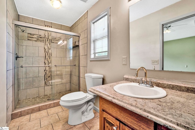 full bathroom featuring toilet, tile patterned flooring, a textured ceiling, vanity, and a shower stall