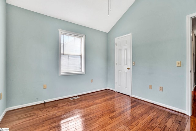 unfurnished room with high vaulted ceiling, visible vents, baseboards, and hardwood / wood-style flooring