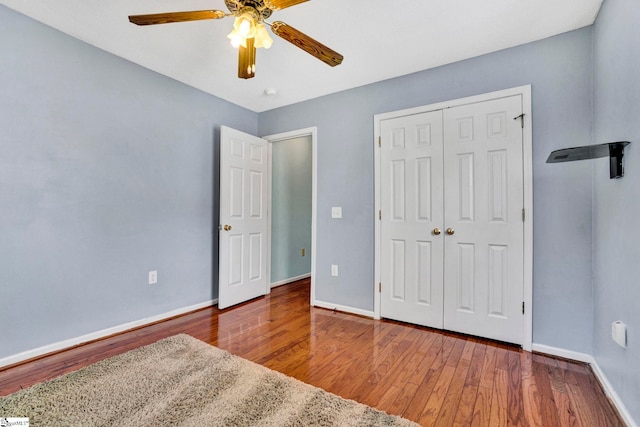 unfurnished bedroom with a closet, baseboards, and wood finished floors