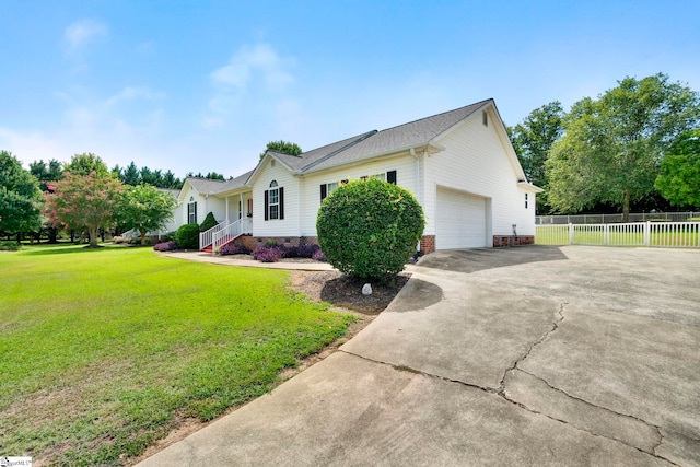 view of side of property with a garage, fence, driveway, crawl space, and a lawn