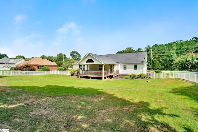 rear view of house with a fenced backyard, a lawn, and a deck