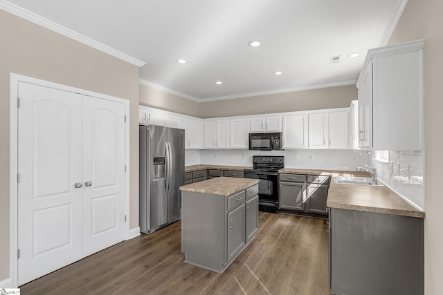 kitchen featuring a kitchen island, dark wood-type flooring, a sink, and black appliances