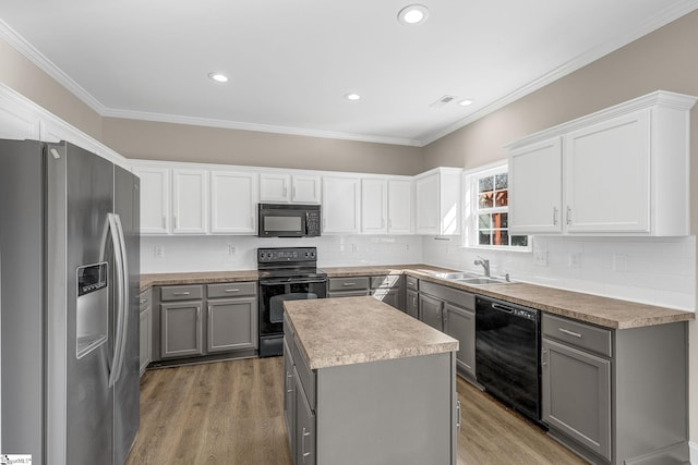 kitchen featuring crown molding, gray cabinets, decorative backsplash, wood finished floors, and black appliances