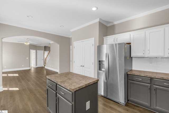 kitchen with white cabinetry, arched walkways, gray cabinets, and stainless steel fridge with ice dispenser