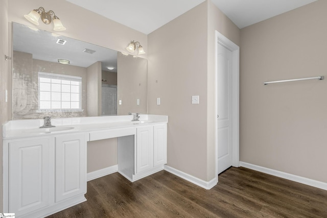 full bath featuring wood finished floors, a sink, visible vents, baseboards, and double vanity