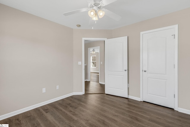 unfurnished bedroom with baseboards, dark wood finished floors, and a ceiling fan