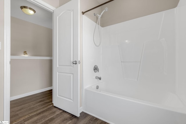 bathroom featuring shower / bathing tub combination, baseboards, and wood finished floors