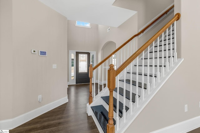 entrance foyer featuring a high ceiling, wood finished floors, visible vents, baseboards, and stairway