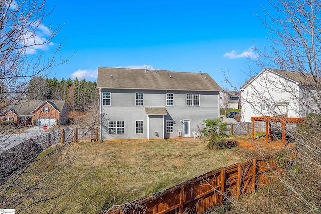 rear view of property with a gate, a fenced backyard, and a yard