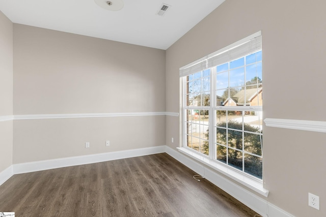 empty room featuring baseboards, wood finished floors, and a healthy amount of sunlight