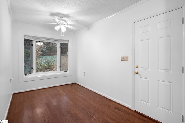 spare room with crown molding, a textured ceiling, baseboards, and dark wood-style flooring