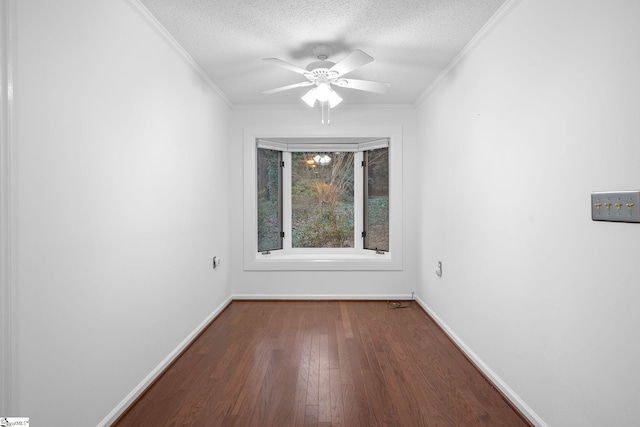 empty room featuring baseboards, a ceiling fan, wood finished floors, a textured ceiling, and crown molding