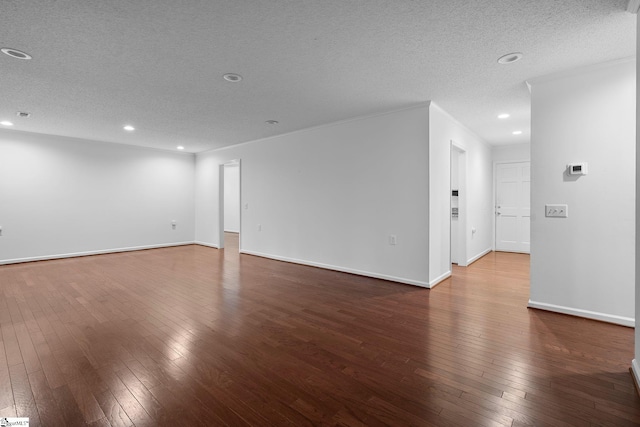 empty room featuring baseboards, a textured ceiling, and hardwood / wood-style floors