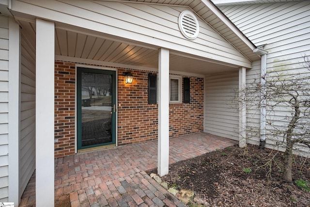 entrance to property featuring brick siding