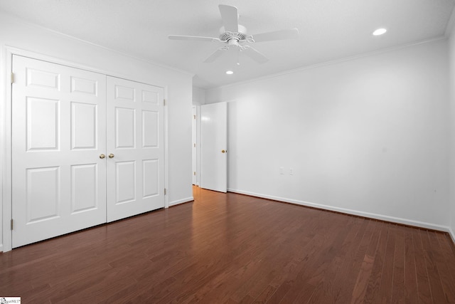 unfurnished bedroom featuring crown molding, a closet, baseboards, and dark wood-type flooring