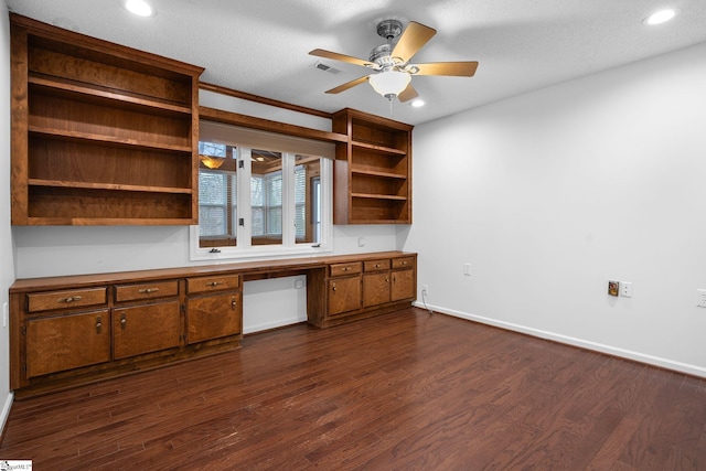 unfurnished office with dark wood-style floors, baseboards, visible vents, and built in study area