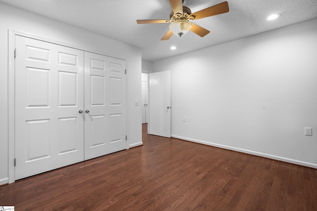 unfurnished bedroom with dark wood-type flooring, a textured ceiling, and baseboards