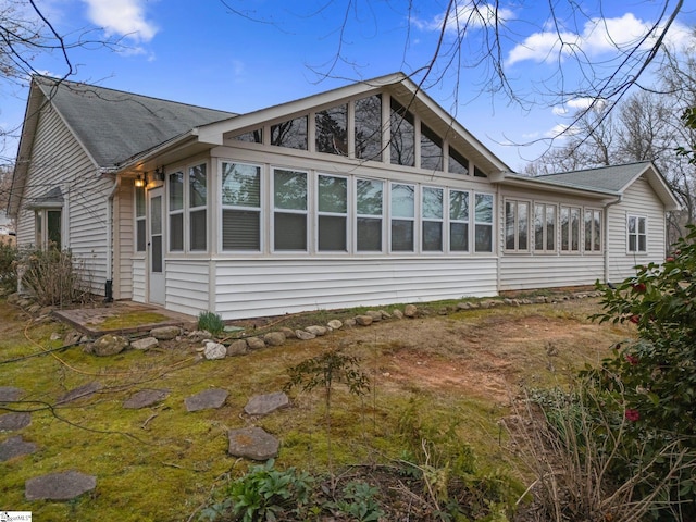 view of property exterior with a sunroom