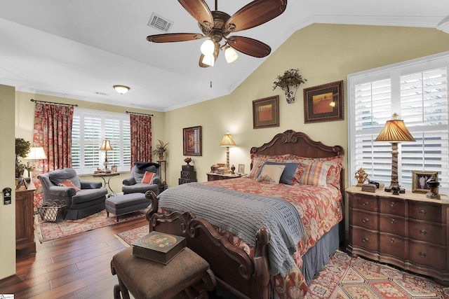 bedroom with visible vents, lofted ceiling, ceiling fan, ornamental molding, and wood finished floors