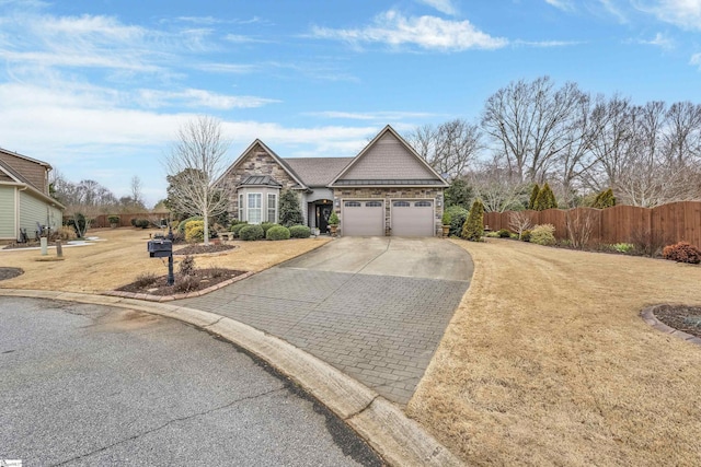 view of front facade with concrete driveway, an attached garage, fence, stone siding, and a front lawn