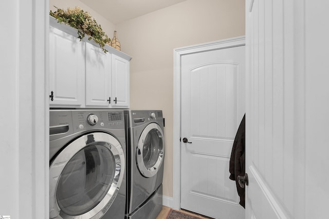 laundry room featuring washing machine and clothes dryer and cabinet space