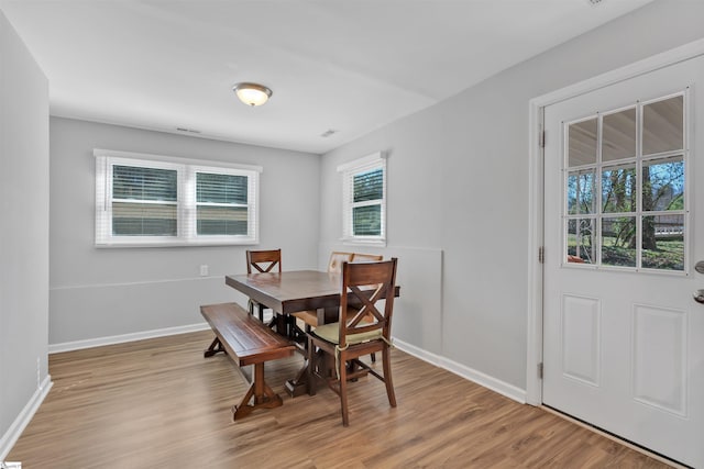 dining area with baseboards and light wood-style floors