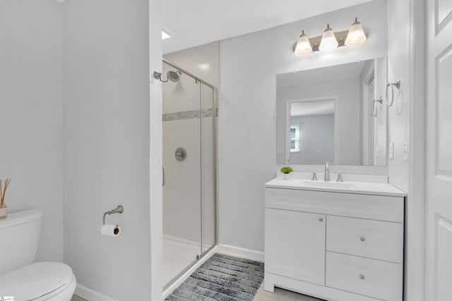 full bath featuring toilet, a stall shower, baseboards, and vanity