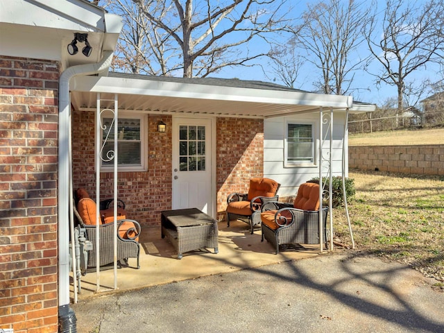 exterior space featuring brick siding, a patio, and fence