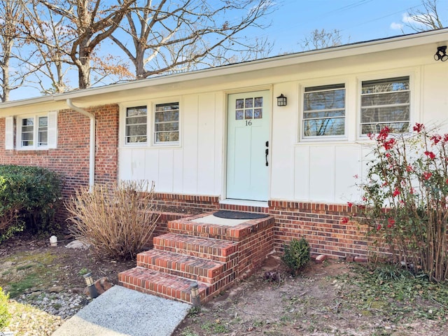 property entrance with brick siding and board and batten siding