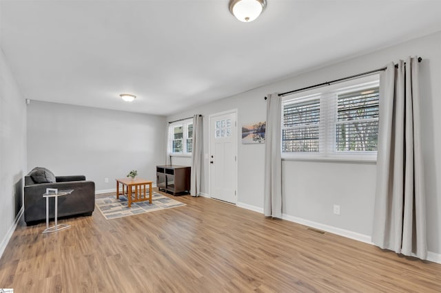 sitting room with light wood-type flooring, baseboards, and visible vents