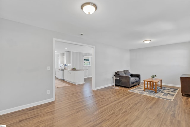 living area featuring light wood finished floors and baseboards