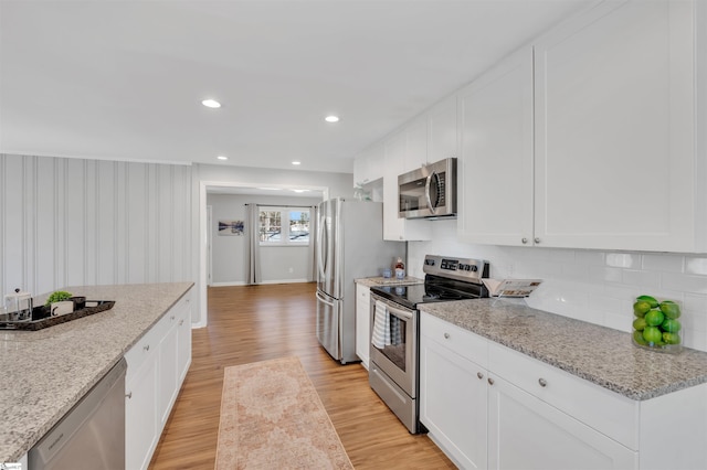 kitchen featuring appliances with stainless steel finishes, white cabinetry, and light wood-style floors