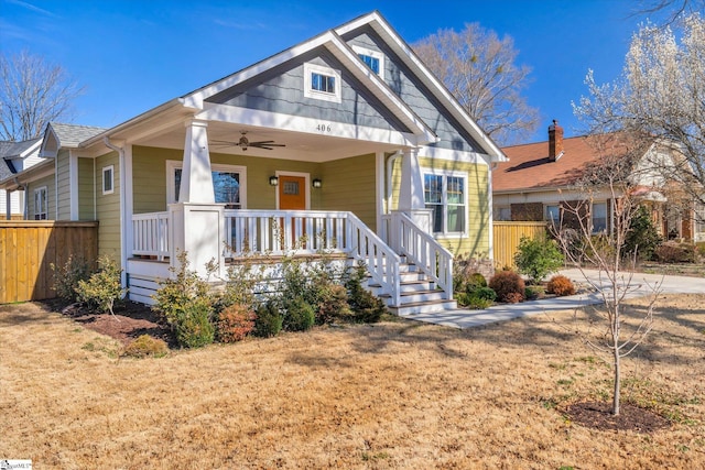 bungalow-style home featuring a front lawn, a porch, and a ceiling fan