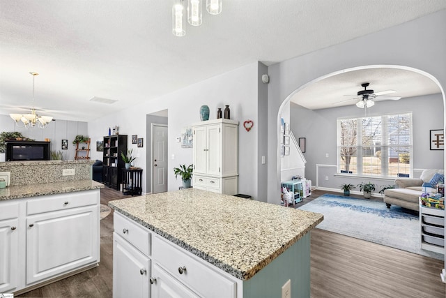 kitchen featuring open floor plan, dark wood-style flooring, and white cabinetry