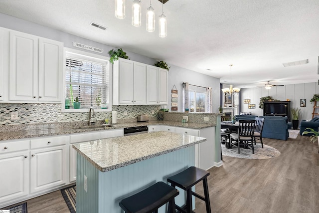 kitchen with plenty of natural light, visible vents, a sink, and wood finished floors